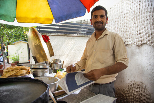 Male vendor selling paratha at his roadside food stall