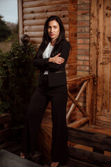 beautiful girl with black hair dressed in a black business suit on the street