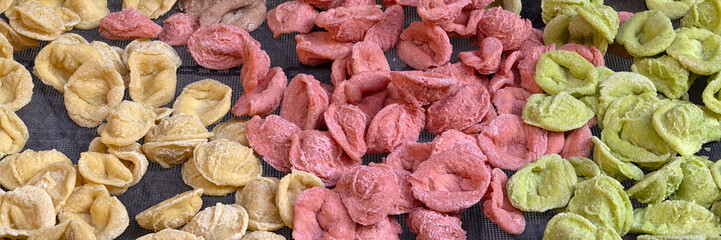 Panorama of traditional freshly handmade orecchiette pasta in differing colours