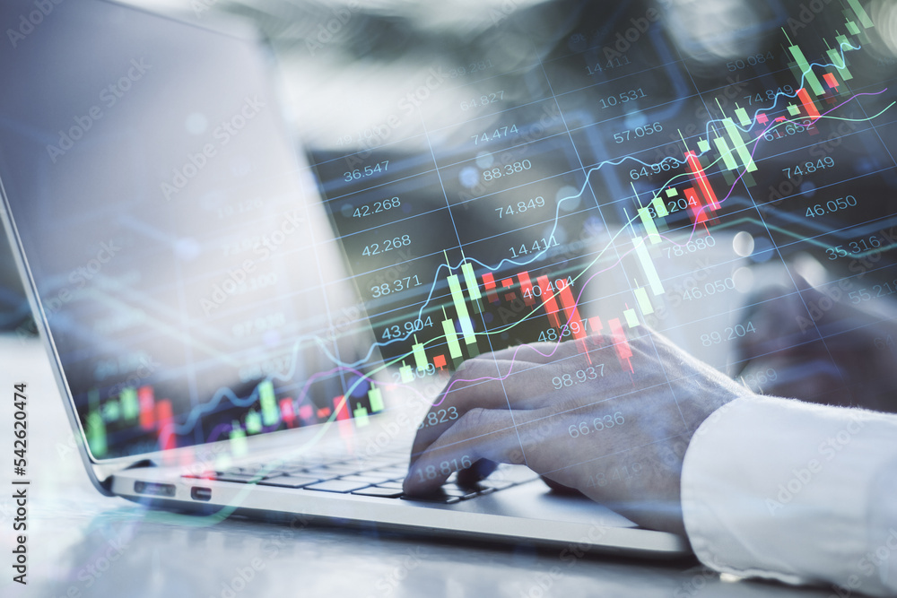 Poster hands using laptop keyboard at desktop with coffee cup and creative candlestick forex chart index hologram on blurry background. Trade, business market and finance analysis concept. Double exposure.