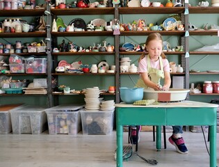 The child works with clay. Pottery workshop. Children's creativity. The child is a potter.