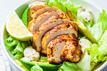 Grilled chicken breast salad with avocado and caesar dressing. Keto diet food.