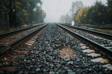 Railroad track rails in coutry landspace in autumn weather with foggy landscape. Industrial concept. Railroad travel, railway tourism.