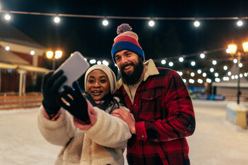 Selfie portrait of biracial couple while ice skating