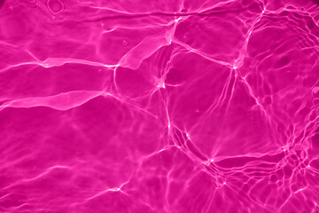Defocus blurred transparent purple colored clear calm water surface texture with splash, bubble. Shining purple water ripple background. Surface of water in swimming pool. Purple bubble water shine.
