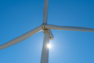 Close up view of the rotating blades and head of a wind turbine.