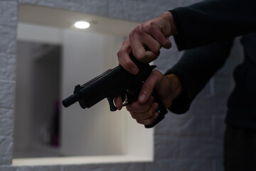 Threat of firearms. Muzzle of gun in man's hand is pointed at camera. Male criminal holds revolver...