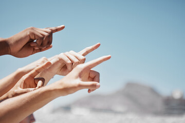 Group hands, fingers and pointing to sky mockup, direction and advertising space of global community outdoors. Closeup diversity people showing body language sign to blue sky, hope and ideas