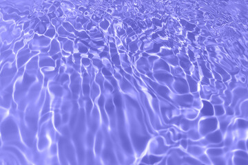 Defocus blurred transparent purple colored clear calm water surface texture with splash, bubble. Shining purple water ripple background. Surface of water in swimming pool. Purple bubble water shine.