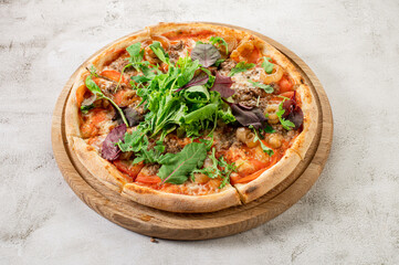 Fresh pizza with meat and vegetables on the concrete background