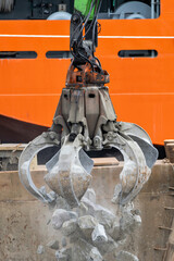 excavator claw moving natural stones for transport