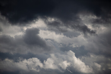 Clouds that portend rain creep into the blue sky