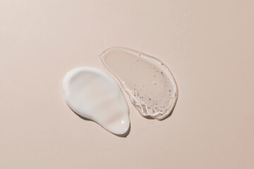 White cream and transparent gel texture on a baige background. cosmetic cream stroke, face care...