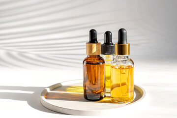 Set of skin, body and hair care essential oil, serum in glass dropper bottles on a tray. Beauty treatment still life.