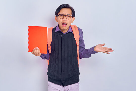 Unhappy Young Asian Students With Backpacks Holding Books Showing Rejection Or Hopeless Surrender Gesture Isolated On Gray Background. Education In High School University College Concept