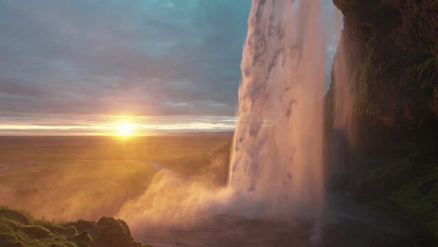 Beautiful Seljalandsfoss waterfall flowing and midnight sunset shining on summer at South of Iceland