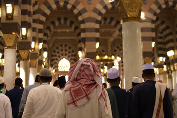 Naklejka premium Crowd of Muslim people inside Nabawi Mosque. Interior view of Masjidil Nabawi (Nabawi Mosque) in Medina.
