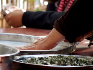 Upclose shot of a woman's hands as she rolls out dough by hand