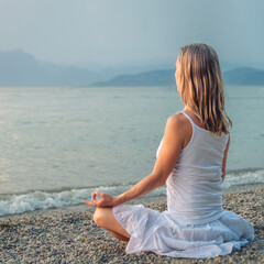 Fototapeta na wymiar Woman meditating at the Garda Lake. Sunset.