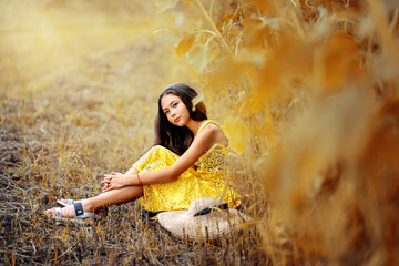 A beautiful girl walks in a sunflower field. A sunny field and a girl.