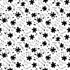 Childish style flowers seamless pattern with tiny dots. Brush drawn black floral silhouettes. Graphic sketch drawing of small daisies, simple chamomiles with leaves. Black ink illustration.