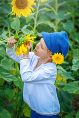 A boy on a sunflower mole, A child playing with sunflowers and eating sunflower seeds