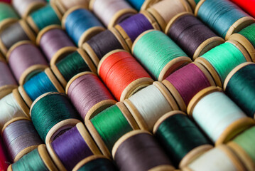 Multi-colored spools of thread close-up. Sewing threads multicolored background closeup