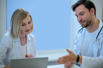 Two doctors sitting close and discussing something
