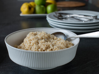 Bowl with cooked brown rice on a dinner table