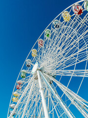 Panoramic Ferris wheel with no people against blue sky