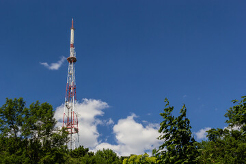 Telecommunication tower for mobile phone with antennas over a blue sky. Distribution function of...