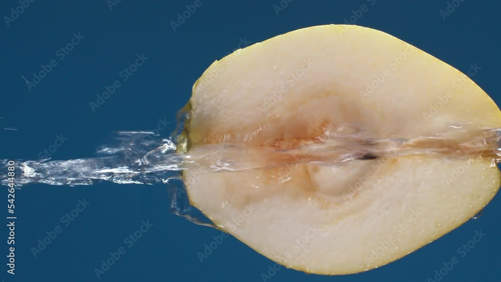 Poster vertical yellow half pear on a blue dark background with drops of water rolling down the pear and fl