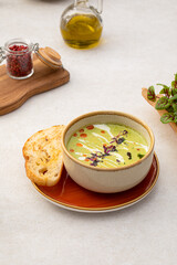 Portion of gourmet broccoli cream soup with bread