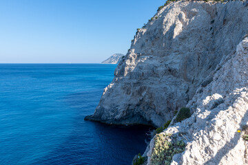 Dramatic cliffs dropping into deep blue sea.