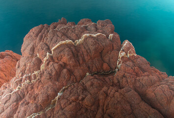 détail roche rouge volcanique au bord de l'eau