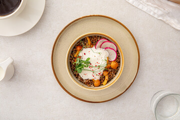 Portion of buckwheat porridge with sour cream and mushrooms