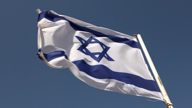 israel flag fluttering in the wind. real footage not graphics. flag against a clear blue sky and in the wind. High quality 4k footage