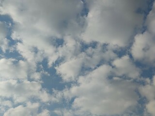 Pale blue sky with clouds. Autumn evening high in the sky are translucent white-gray cirrus clouds. They are blurry translucent through them you can see the pale blue sky.