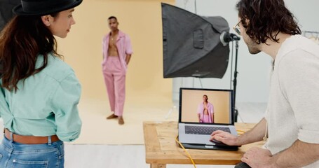 Laptop, photography and model in studio with photographer and editor shooting a cool fashion magazine cover. Creative, cameras and young people in collaboration, teamwork and coworking backstage