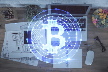 Blockchain theme hologram drawings over computer on the desktop background. Top view. Double...