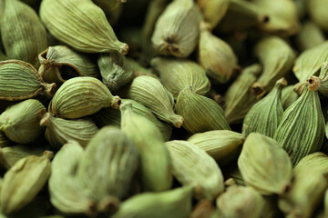 Dry green cardamom pods as background, closeup