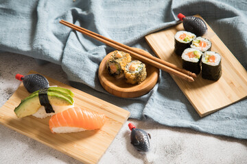 Lachs Avocado Sushi als Nigiri, Maki, roh und knusprig frittiert auf Holz Teller mit Soja Soße in...
