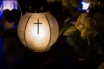 Votive candle burning at a cemetery at night