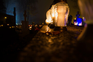 Votive candle burning at a cemetery at night