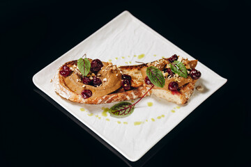 Liver pate on crusty bread decorated with cherries.