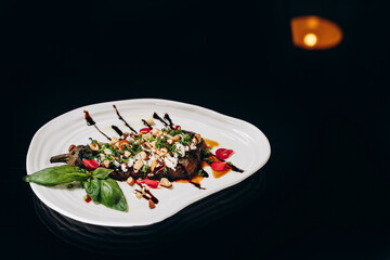 Eggplant stuffed with feta, nuts and green onions, decorated with balsamic sauce.