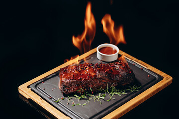 Juicy meat seasoned with red pepper and herbs. Sprinkle with alcohol and set on fire. Burning with...