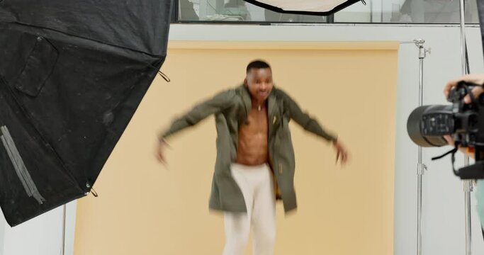 Fashion, studio photoshoot and a black man or model jumping on studio background. Backstage at photography shoot with male model, celebrity or influencer and woman photographer for magazine article.