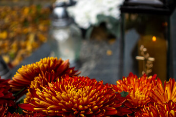 Candles and flowers on graves in the cemetery during the All Saint's Day. Taken during the day,...