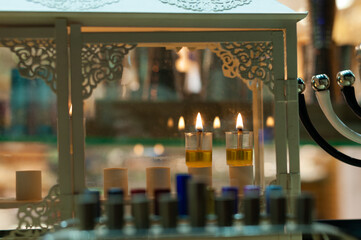 A glowing Hanukkah menorah lit with small vials of oil burns in protective glass housing in a store in Jerusalem during the celebration of the Festival of Lights in Israel.